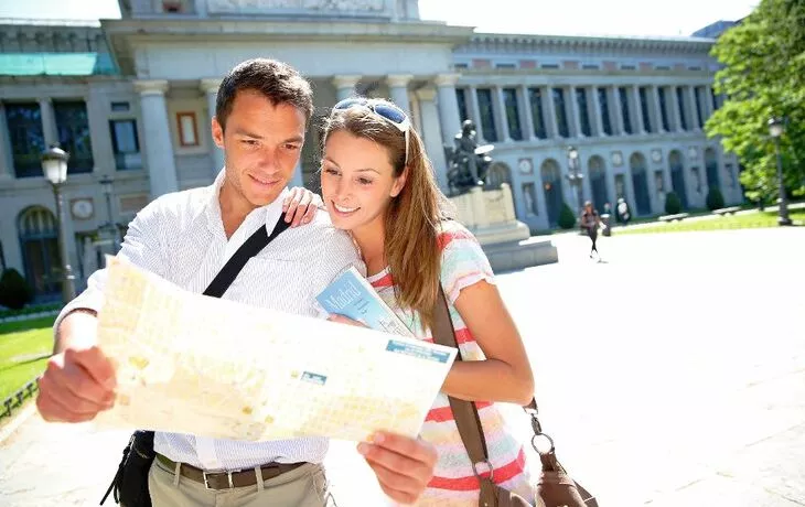 Couple reading city map in front of Prado museum, Madrid