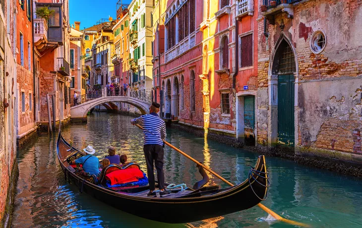 schmaler Kanal mit Gondel und Brücke in Venedig