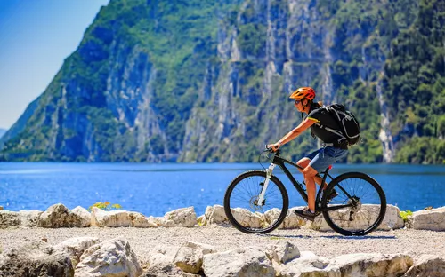 radfahrende Frau am Seeufer des Gardasees in Italien