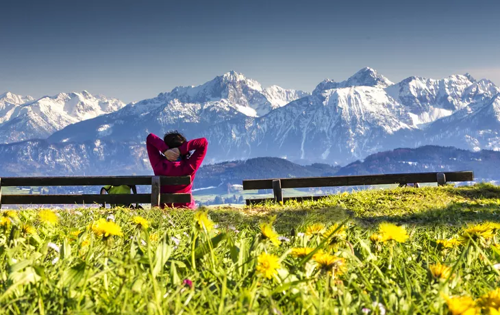 Frau geniesst das Panorama auf der Bank